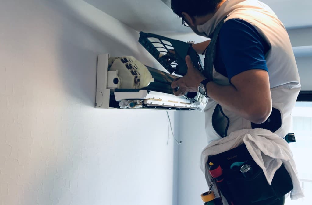 有限会社ティーファクトリーの技術者が空調・配管メンテナンスを行う様子